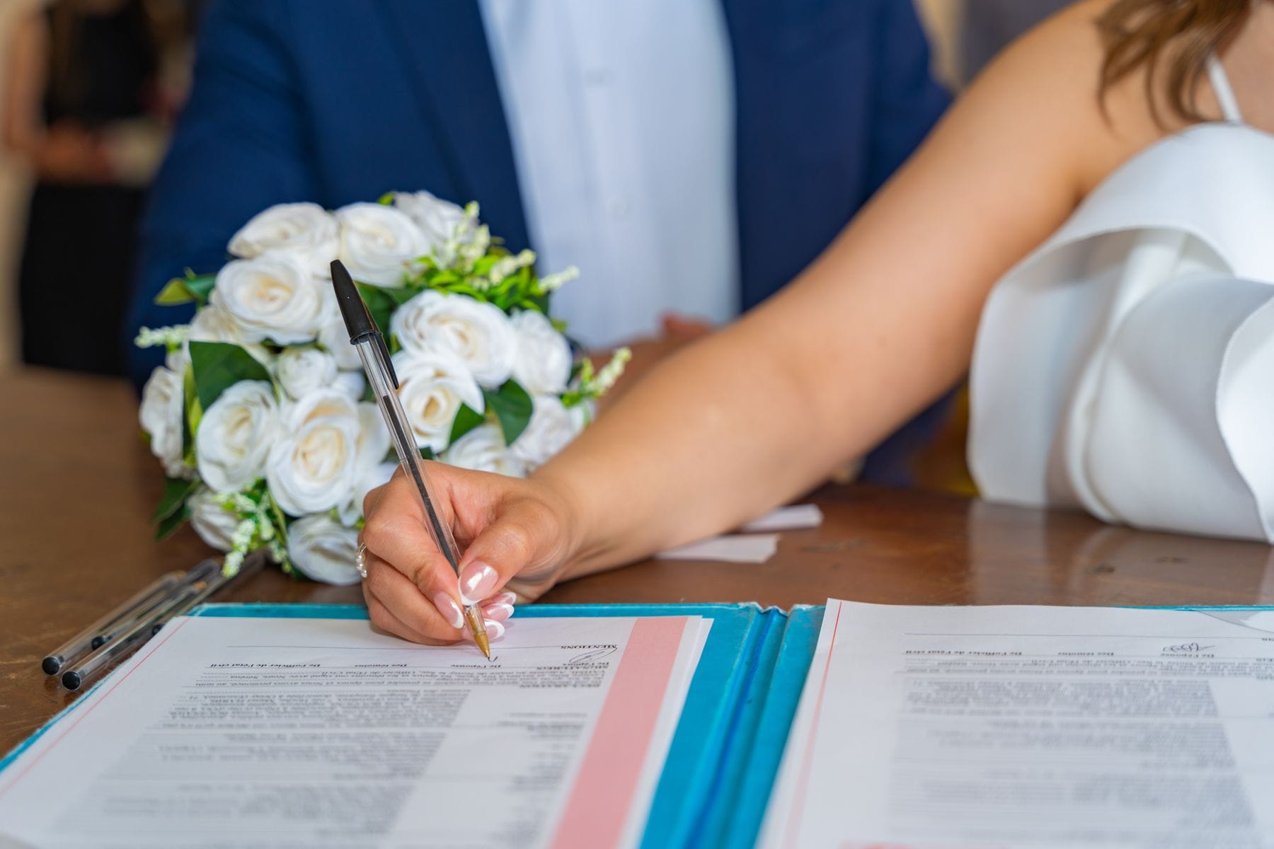 A couple signing a marriage contract with a pen