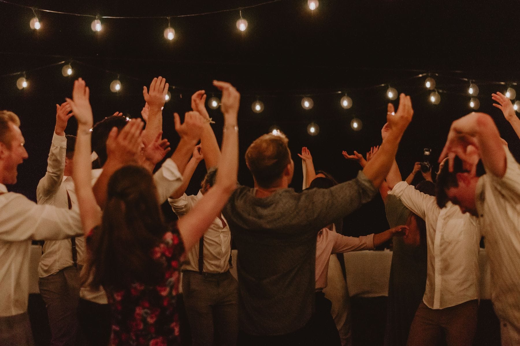Guests dancing under string lights