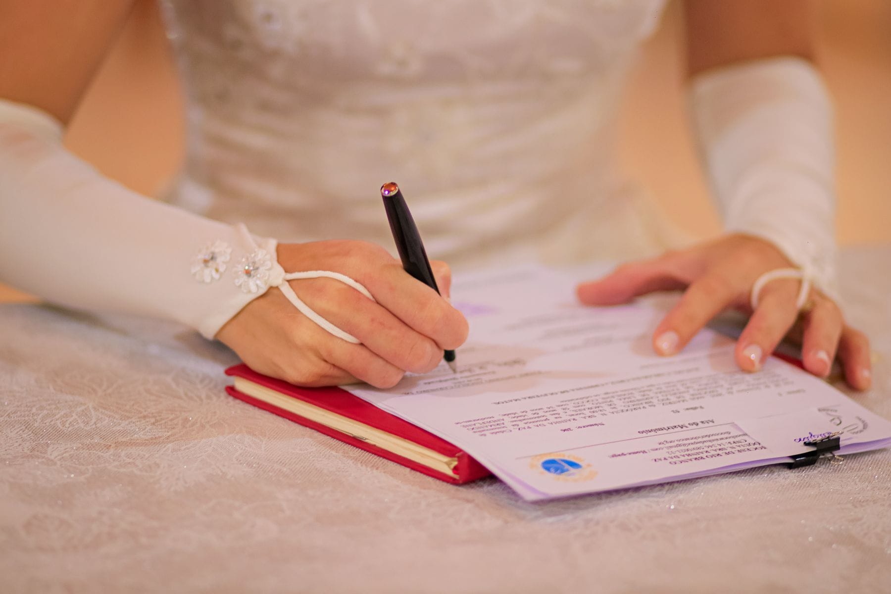 Couple signing wedding certificate close up