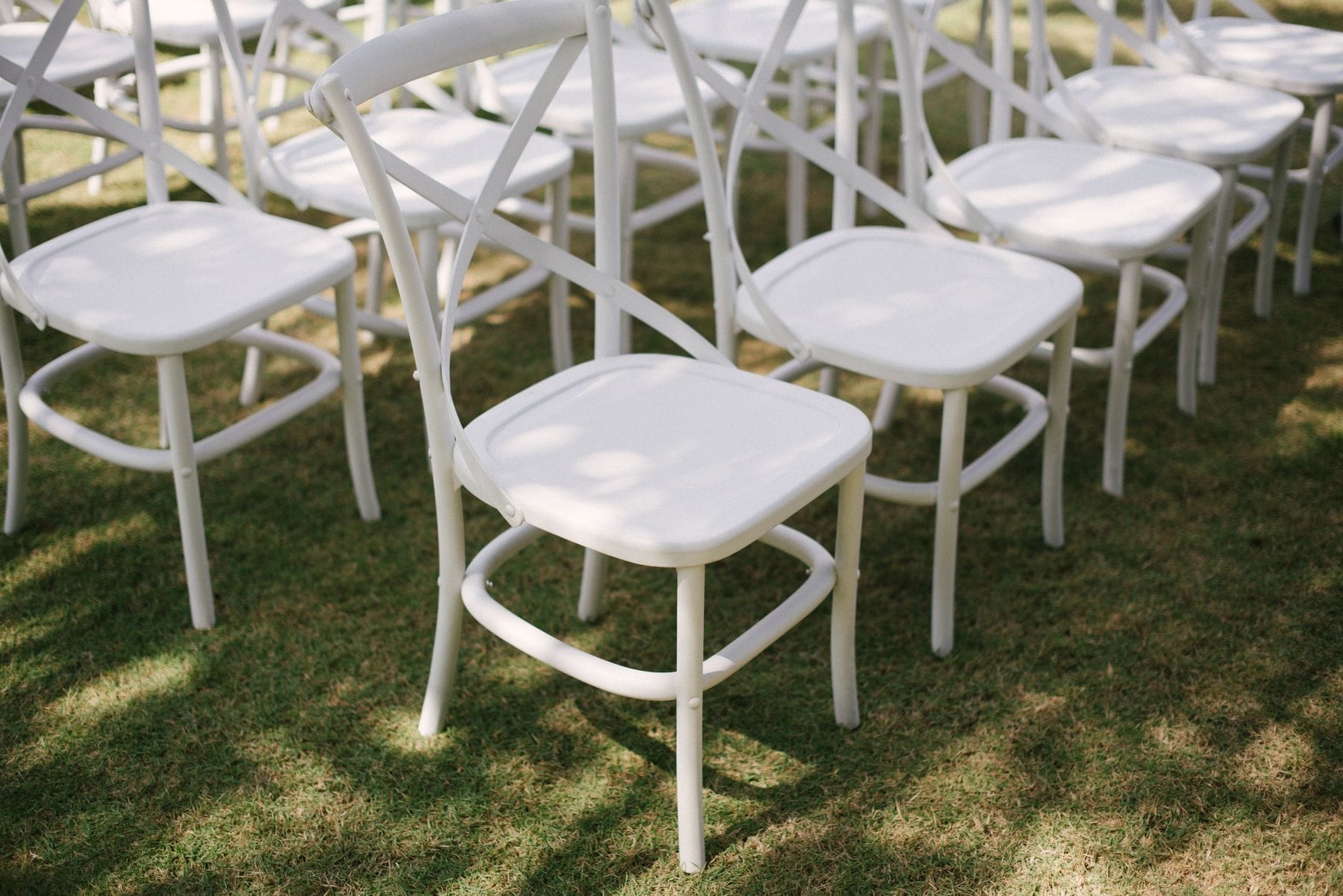 Elegant white wedding chairs on lawn