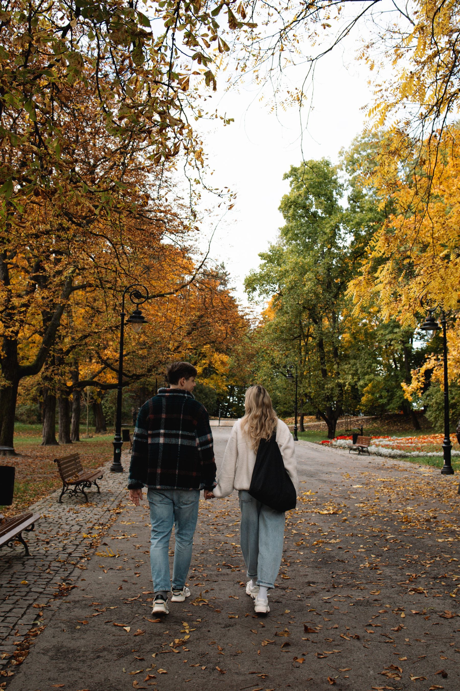 Couple strolling through autumn park pathway